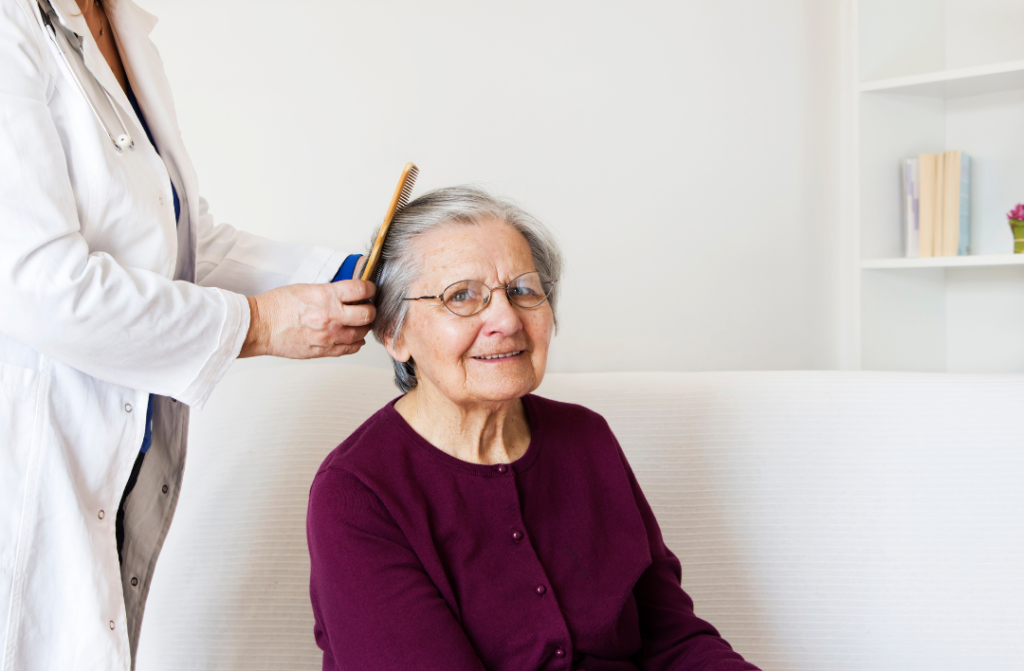 A carer combing an elderly's hair