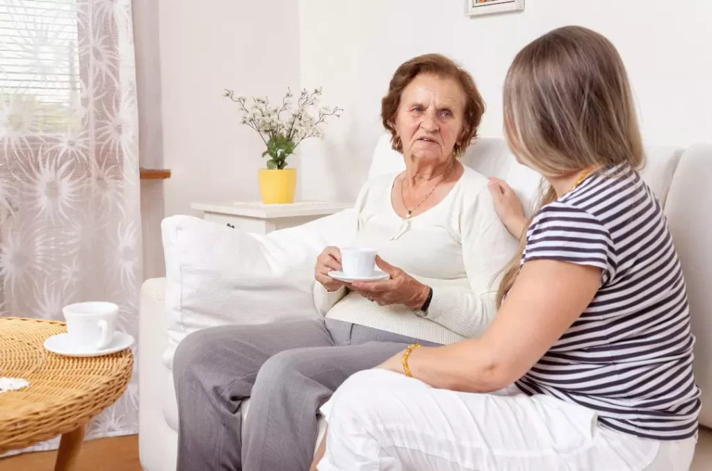 An elderly woman sitting in the couch